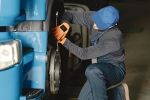 Home VP Auto Peças 32 Homem verificando os freios de um caminhão.